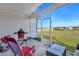 Relaxing screened porch area featuring a grill, chair, and view of the spacious backyard at 308 Cypress Branch Rd, Huger, SC 29450
