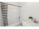 Well-lit bathroom with a shower-tub featuring a striped curtain, white sink, and toilet at 3107 S Shore Dr, Charleston, SC 29407