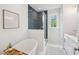 Modern bathroom featuring a soaking tub, a glass shower with blue tile, and marble-look flooring at 3107 S Shore Dr, Charleston, SC 29407