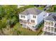 Charming coastal home featuring a spacious screened porch and elevated construction with lush landscaping at 3107 S Shore Dr, Charleston, SC 29407