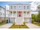 Stunning two-story home with a red front door, white railings, and a two-car garage at 3107 S Shore Dr, Charleston, SC 29407