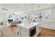 Bright and airy kitchen and living room with white cabinets, stainless steel appliances, and an island at 3107 S Shore Dr, Charleston, SC 29407