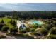 Aerial view of the community pool with yellow umbrellas, a barn building, and a beautiful green lawn and trees at 320 Archar St, Summerville, SC 29486