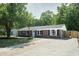 Charming brick ranch-style home with a well-manicured lawn, mature trees, and a long driveway at 3227 Stonehaven Dr, North Charleston, SC 29420