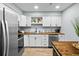 Modern kitchen featuring white cabinets, butcher block countertops, and stainless steel appliances at 3227 Stonehaven Dr, North Charleston, SC 29420
