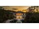 A home exterior at sunset features two stories, a fountain, balcony, black shutters and manicured landscaping at 3547 Holmgren St, Mount Pleasant, SC 29466