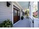 Welcoming front porch with gray wood flooring and double wood front doors at 3547 Holmgren St, Mount Pleasant, SC 29466