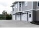 Attached three car garage featuring paneled doors, gray siding, and an extra entry door at 3547 Holmgren St, Mount Pleasant, SC 29466