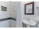 Bathroom with tiled walk-in shower, accent mosaic tile, pedestal sink, and decorative mirror at 405 Cross St, Charleston, SC 29407