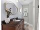 Bathroom featuring dark wood vanity, decorative mirror, granite countertop, and tiled floors at 405 Cross St, Charleston, SC 29407