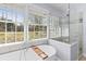 Luxurious bathroom with a soaking tub, glass-enclosed shower, and a bright window at 405 Cross St, Charleston, SC 29407