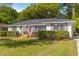 Inviting single-story home with a brick exterior, lush landscaping, and a well-maintained lawn at 405 Cross St, Charleston, SC 29407