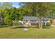 Charming home with a well-manicured lawn, mature trees, and a welcoming yellow front door at 405 Cross St, Charleston, SC 29407