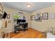 Well-lit home office with hardwood floors, built-in desk, and a window offering natural light at 405 Cross St, Charleston, SC 29407
