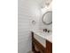 Elegant bathroom features a custom vanity with a farmhouse sink, modern faucet, and round mirror at 406 King Charles Cir, Summerville, SC 29485
