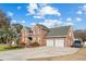 Beautiful two-story brick home features an attached two-car garage and a palm tree at 406 King Charles Cir, Summerville, SC 29485