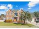 Stately brick home boasts a manicured lawn, mature landscaping, and a two-car garage at 406 King Charles Cir, Summerville, SC 29485