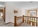 Second-floor hallway featuring neutral carpet, hardwood trim, and open view down to the front entry at 406 King Charles Cir, Summerville, SC 29485