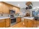 Well-equipped kitchen with modern stainless steel appliances, wooden cabinets, and a seamless flow to the living spaces at 406 King Charles Cir, Summerville, SC 29485