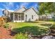 Well-manicured backyard with lawn, mature trees, flower beds, and screened porch at 411 Freeland Way, Moncks Corner, SC 29461