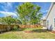 Fenced backyard with a tree, grass, landscaping, and a screened porch at 411 Freeland Way, Moncks Corner, SC 29461