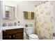 Clean bathroom with a white toilet, a sink with dark cabinetry and matching mirror, and a shower with curtain at 411 Freeland Way, Moncks Corner, SC 29461