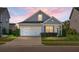 Charming single-Gathering home with a well-manicured lawn and a two-car garage at dusk at 411 Freeland Way, Moncks Corner, SC 29461