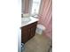 Well-lit bathroom with a modern vanity, neutral tile flooring, and a pink shower curtain at 4210 Scharite St, Charleston, SC 29414