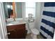 Bathroom with a vanity, toilet, and blue and white striped shower curtain at 4210 Scharite St, Charleston, SC 29414