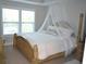 Serene bedroom with a canopy bed, plush bedding, and natural light streaming through the windows at 4210 Scharite St, Charleston, SC 29414