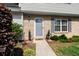 Welcoming front entrance with brick facade, blue door, green bushes, and charming decorations on a sunny day at 422 Temple Rd, Ladson, SC 29456