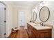 Bathroom with double sink vanity, granite countertop, wood cabinets, and hardwood floors at 43 Montrose Rd, Mount Pleasant, SC 29464