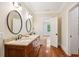 Bathroom featuring double sinks, a wood vanity, hardwood floors, and a view into the next room at 43 Montrose Rd, Mount Pleasant, SC 29464