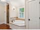Elegant bathroom with a soaking tub, tiled surround, and a window providing natural light and a view at 43 Montrose Rd, Mount Pleasant, SC 29464