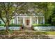 Inviting home exterior with a classic porch, framed by a beautiful tree and landscaped yard at 43 Montrose Rd, Mount Pleasant, SC 29464