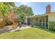 Landscaped backyard with a covered patio, lush lawn, and cozy seating area with fire pit at 45 Lyttleton Ave, Charleston, SC 29407