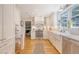 Bright kitchen features white cabinets, countertops, stainless appliances, and a window over the farmhouse sink at 45 Lyttleton Ave, Charleston, SC 29407