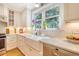 Bright kitchen features white cabinets, countertops, stainless appliances, and a window over the farmhouse sink at 45 Lyttleton Ave, Charleston, SC 29407