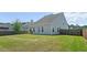 View of the home's backyard, featuring a spacious lawn and wooden fence for privacy at 514 Morelets Dr, Moncks Corner, SC 29461