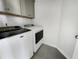 A modern laundry room includes a washing machine and dryer with cabinets for storage at 572 Dunswell Dr, Summerville, SC 29486