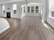 Open-concept living room with fireplace, ample windows, and beautiful wood floors, ideal for gatherings at 572 Dunswell Dr, Summerville, SC 29486