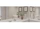 Bright bathroom featuring double sinks, quartz countertops, decorative mirrors, and elegant design elements at 596 Red Monarch Way, Moncks Corner, SC 29461