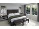 Stylish bedroom featuring a dark wood headboard, neutral bedding, bedside lighting, and natural light from the windows at 596 Red Monarch Way, Moncks Corner, SC 29461