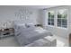 Serene bedroom with a large window, cozy bedding, stylish side tables, and soft neutral color palette at 596 Red Monarch Way, Moncks Corner, SC 29461