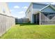 Large, fenced backyard features healthy green lawn and a screened in porch at 613 Ravens Wood Rd, Summerville, SC 29486