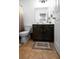 Functional bathroom with a dark vanity, a square mirror, and neutral-toned flooring at 613 Ravens Wood Rd, Summerville, SC 29486
