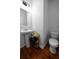 This bathroom features a toilet, a pedestal sink, a mirror, and wooden floors at 613 Ravens Wood Rd, Summerville, SC 29486