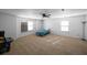 Spacious carpeted bedroom featuring a ceiling fan, windows, and a classic arcade game at 613 Ravens Wood Rd, Summerville, SC 29486