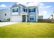 Two-story home featuring light gray siding, black shutters, a well-manicured lawn, and a two-car garage at 613 Ravens Wood Rd, Summerville, SC 29486
