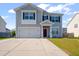 Two-story house showcasing gray siding, black shutters, an attached two-car garage and paved driveway at 613 Ravens Wood Rd, Summerville, SC 29486